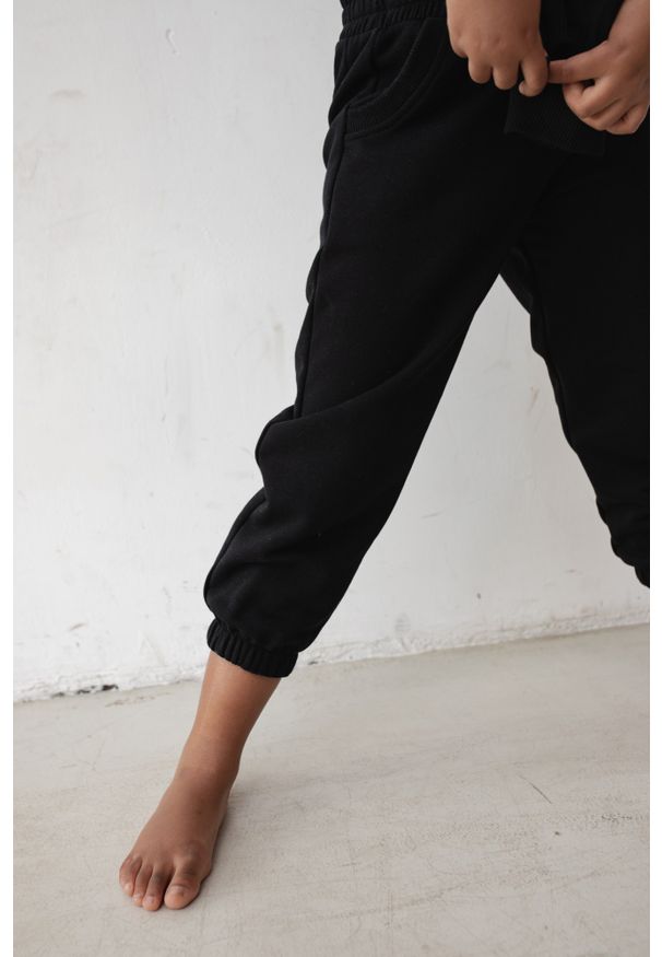 Marsala - MINI spodnie dresowe typu jogger w kolorze TOTALLY BLACK - DISPLAY-80-86 (12-18). Stan: podwyższony. Kolor: czarny. Materiał: dresówka. Wzór: gładki