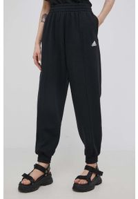 Adidas - adidas spodnie damskie kolor czarny gładkie. Stan: podwyższony. Kolor: czarny. Materiał: dzianina, materiał, włókno, bawełna. Wzór: gładki