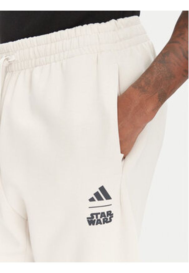 Adidas - adidas Spodnie dresowe Star Wars The Mandalorian™ JI5723 Beżowy Regular Fit. Kolor: beżowy. Materiał: syntetyk. Wzór: motyw z bajki