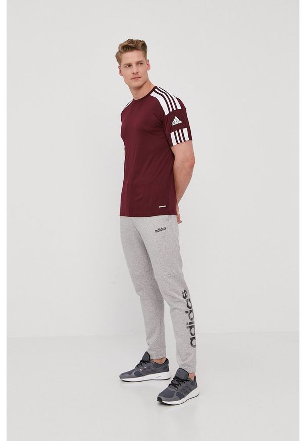 Adidas - adidas Spodnie męskie kolor szary z nadrukiem. Kolor: szary. Materiał: dzianina, poliester. Wzór: nadruk