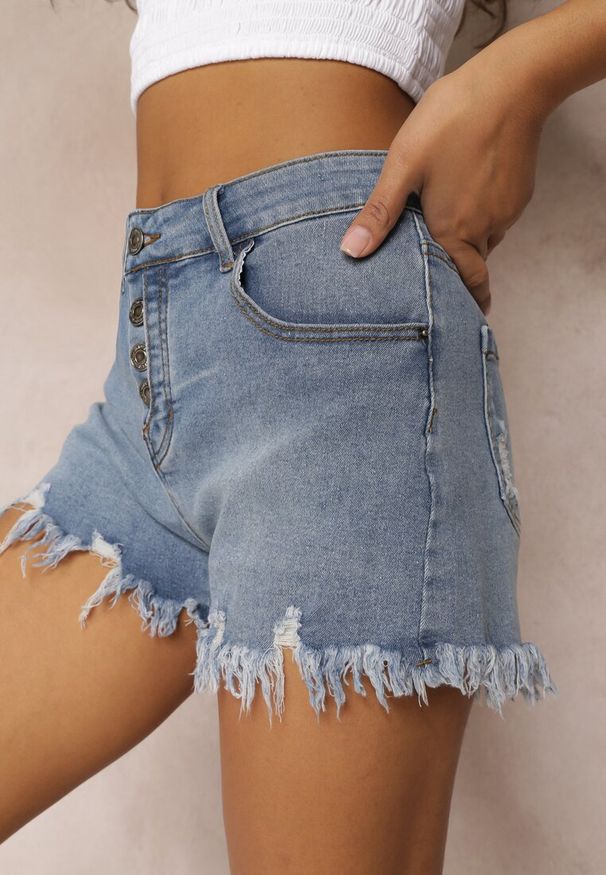 Renee - Jasnoniebieskie Szorty Jeansowe z Postrzępionymi Krawędziami i Guzikami Daenanea. Kolor: niebieski. Materiał: jeans