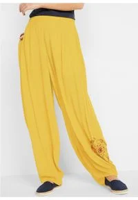 Spodnie z szerokimi nogawkami, wygodnym paskiem w talii i nadrukiem z boku bonprix żółty curry. Kolor: żółty. Wzór: nadruk #7