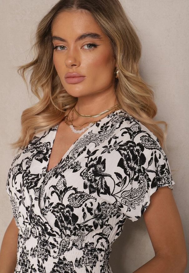 Renee - Biała Sukienka z Bawełną i Kopertowym Dekoltem w Kwiaty Ldivisa. Okazja: na plażę, na spacer. Typ kołnierza: dekolt kopertowy. Kolor: biały. Materiał: bawełna. Wzór: kwiaty. Typ sukienki: kopertowe