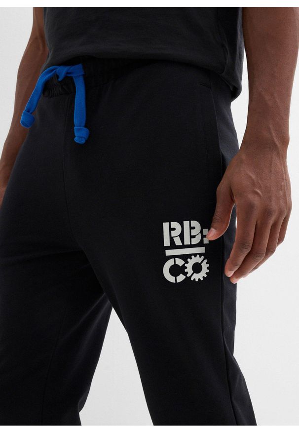 bonprix - Spodnie sportowe z kontrastowymi elementami. Kolor: czarny. Materiał: dresówka, poliester. Wzór: nadruk. Styl: sportowy