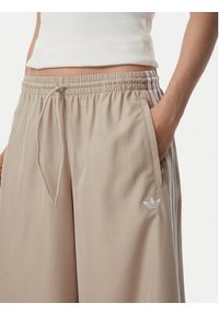 Adidas - adidas Spodnie dresowe Firebrid Adilenium Track KT0019 Beżowy Relaxed Fit. Kolor: beżowy. Materiał: syntetyk #3