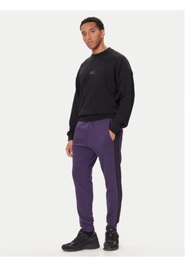 Adidas - adidas Spodnie dresowe Essentials 3-Stripes JX0750 Fioletowy Regular Fit. Kolor: fioletowy. Materiał: bawełna