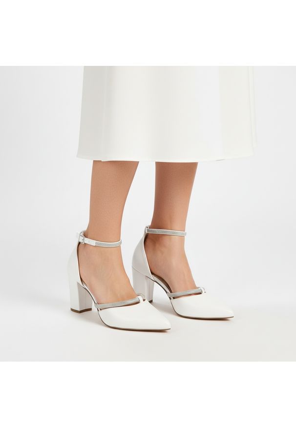 Czółenka damskie Marco Tozzi, ze skóry naturalnej na stabilnym słupku zapewniającym wygodę z paskiem wokół kostki poprawiającym dopasowanie i stabiln. Zapięcie: pasek. Kolor: biały. Materiał: skóra. Obcas: na słupku