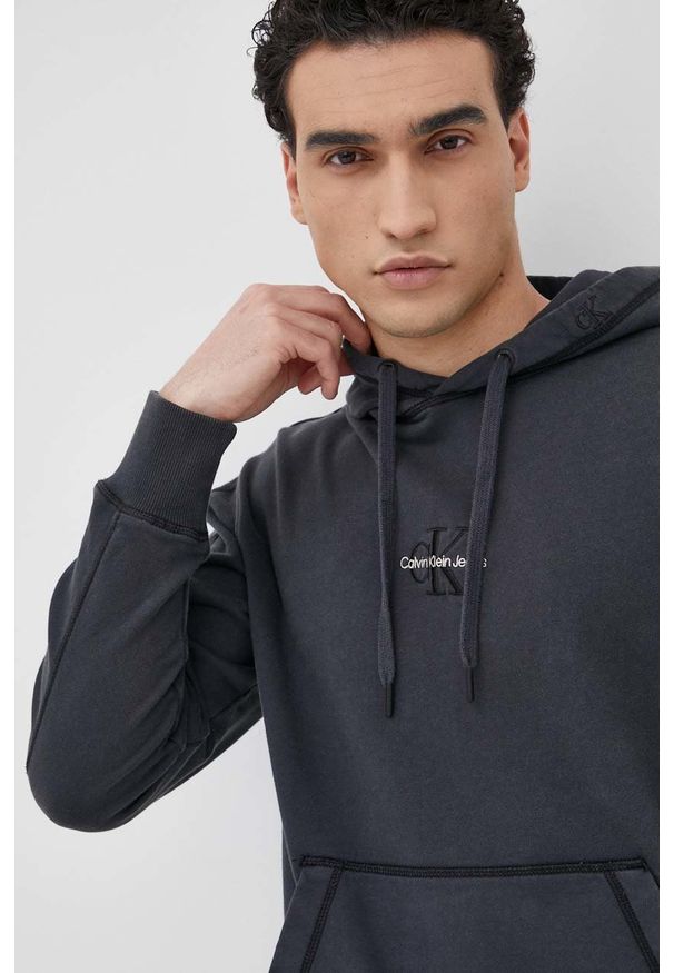Calvin Klein Jeans bluza męska kolor czarny z kapturem gładka. Okazja: na co dzień. Typ kołnierza: kaptur. Kolor: czarny. Materiał: dzianina. Wzór: gładki. Styl: casual