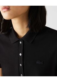 Lacoste - LACOSTE - Czarna bawełniana sukienka z logo. Typ kołnierza: polo. Kolor: czarny. Materiał: bawełna. Wzór: aplikacja. Typ sukienki: proste. Długość: mini