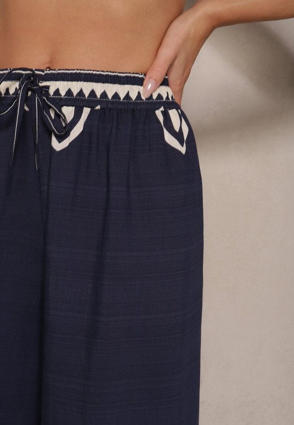 Renee - Granatowe Szerokie Spodnie z Wiskozy z Gumką w Talii Zdobione Etnicznym Wzorem Soleldi. Stan: podwyższony. Kolor: niebieski. Materiał: wiskoza. Wzór: aplikacja. Styl: elegancki