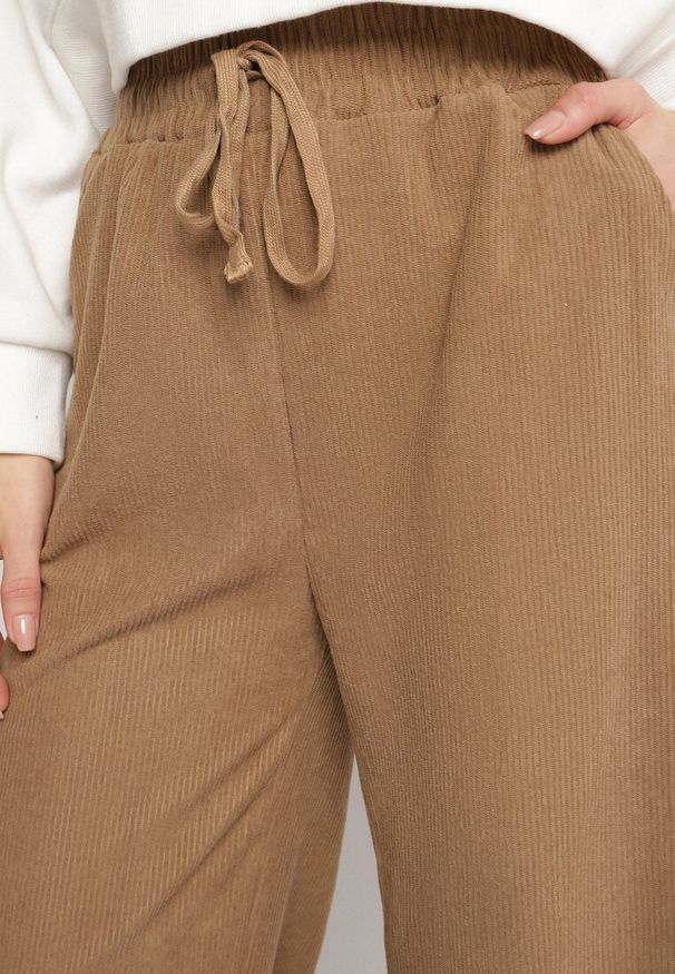 Born2be - Ciemnobeżowe Szerokie Spodnie z Wysokim Stanem Wiązane Sznurkiem Cosetta. Okazja: na co dzień. Stan: podwyższony. Kolor: beżowy. Styl: casual, elegancki