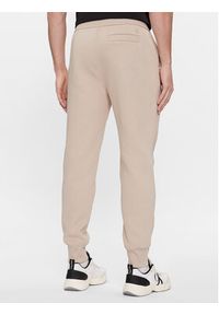 Calvin Klein Jeans Spodnie dresowe Monologo J30J324685 Beżowy Regular Fit. Kolor: beżowy. Materiał: bawełna, dresówka