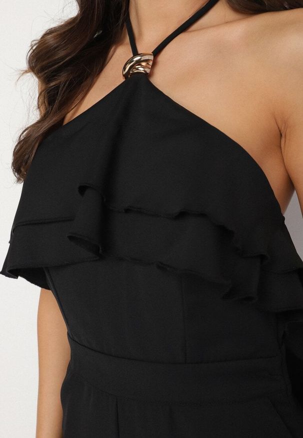 Born2be - Czarny Kombinezon Wiązany na Szyi z Metaliczną Ozdobą Tilindra. Kolor: czarny. Długość: długie. Wzór: aplikacja. Styl: elegancki, klasyczny