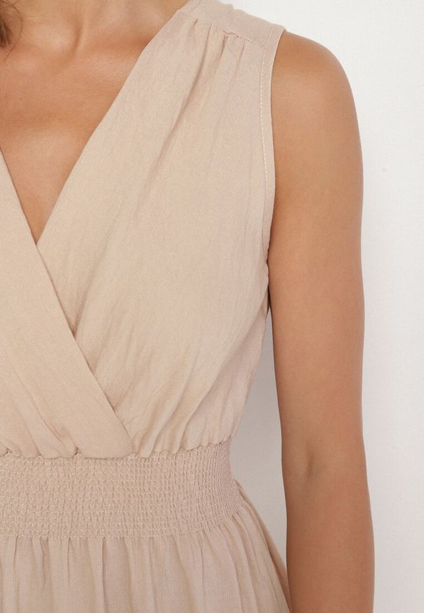 Born2be - Beżowa Kopertowa Sukienka z Wiskozy Bez Rękawów Nalimira. Okazja: na co dzień, na spotkanie biznesowe. Typ kołnierza: dekolt w serek. Kolor: beżowy. Materiał: wiskoza. Długość rękawa: bez rękawów. Typ sukienki: kopertowe. Styl: biznesowy, klasyczny, casual