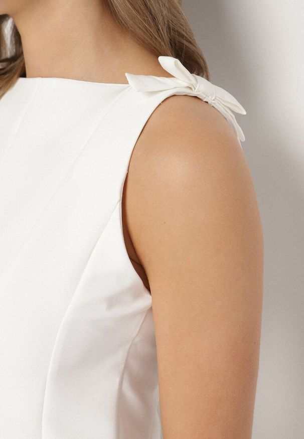 Born2be - Biała Bluzka Bez Rękawów z Baskinką Zdobiona Kokardkami Linopia. Okazja: na co dzień, na randkę. Typ kołnierza: kokarda. Kolor: biały. Materiał: jeans. Długość rękawa: bez rękawów. Wzór: aplikacja. Styl: casual, elegancki