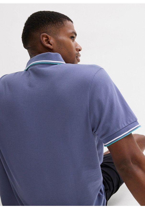 bonprix - Koszulka polo z czystej bawełny organicznej piqué. Typ kołnierza: polo. Kolor: niebieski. Materiał: bawełna. Długość rękawa: krótki rękaw. Długość: krótkie. Wzór: nadruk. Styl: sportowy