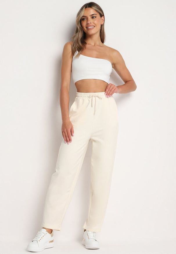 Born2be - Jasnobeżowe Spodnie Dresowe z Wysokim Stanem i Gumką w Pasie Dimka. Okazja: na co dzień. Stan: podwyższony. Kolor: beżowy. Materiał: dresówka. Styl: elegancki, casual