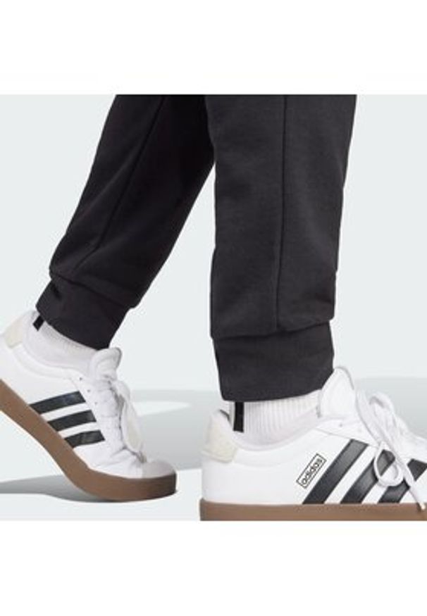 Adidas - adidas Spodnie dresowe Essentials Feel Cozy JE3854 Czarny Regular Fit. Kolor: czarny. Materiał: syntetyk