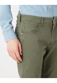 Wrangler - WRANGLER GREENSBORO MĘSKIE SPODNIE JEANSOWE MILITARE GREEN W15Q71G40. Okazja: na spotkanie biznesowe, na co dzień. Stan: obniżony. Styl: biznesowy, sportowy, casual, elegancki