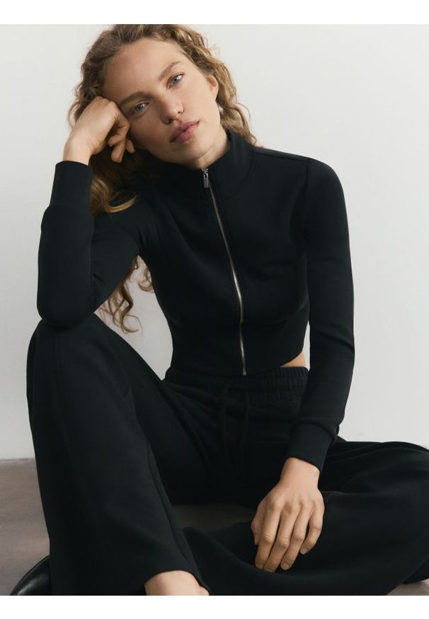 Reserved - Luźne spodnie - czarny. Kolor: czarny. Materiał: dzianina. Wzór: gładki