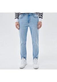 Cropp - Jasnoniebieskie jeansy slim z przetarciami - Niebieski. Kolor: niebieski