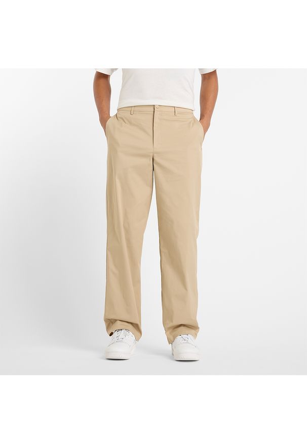 Spodnie męskie New Balance MP43560SOT – beżowe. Kolor: beżowy. Materiał: nylon, materiał, bawełna. Wzór: aplikacja