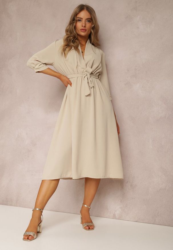 Renee - Beżowa Sukienka Canopis. Typ kołnierza: dekolt kopertowy. Kolor: beżowy. Materiał: materiał, tkanina. Typ sukienki: kopertowe. Styl: elegancki. Długość: midi
