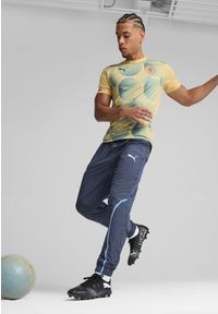 Puma - Męska koszulka przedmeczowa z krótkim rękawem Manchester City PUMA. Kolor: wielokolorowy, niebieski, żółty. Długość rękawa: krótki rękaw. Długość: krótkie