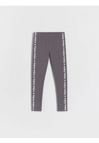 Reserved - Legginsy z ozdobnym nadrukiem - ciemnoszary. Kolor: szary. Materiał: dzianina, włókno, bawełna. Wzór: nadruk