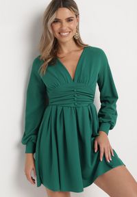 Born2be - Zielona Rozkloszowana Sukienka Mini z Głębokim Dekoltem Ozdobiona Marszczeniem i Guzikami Jerikan. Kolor: zielony. Długość rękawa: długi rękaw. Wzór: aplikacja. Długość: mini #3