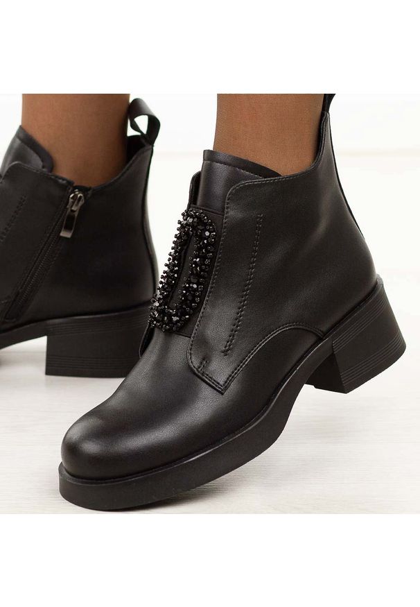 Czarne skórzane botki damskie DiA 52-869. Okazja: na co dzień, do pracy. Nosek buta: okrągły. Kolor: czarny. Szerokość cholewki: normalna. Wzór: aplikacja. Materiał: skóra. Sezon: zima, jesień. Obcas: na obcasie. Styl: klasyczny, casual, elegancki. Wysokość obcasa: niski
