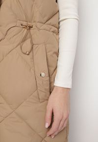 Born2be - Ciemnobeżowa Pikowana Kamizelka o Długim Kroju ze Stójką i Kieszeniami Avatheia. Okazja: na co dzień. Typ kołnierza: kołnierzyk stójkowy. Kolor: beżowy. Materiał: jeans. Długość: długie. Wzór: aplikacja. Styl: elegancki, casual, klasyczny #4