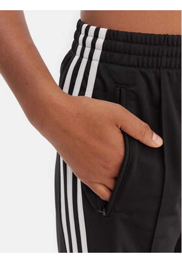 Adidas - adidas Spodnie dresowe Firebird KD7976 Czarny Loose Fit. Kolor: czarny. Materiał: syntetyk