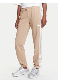 Adidas - adidas Spodnie dresowe Essentials 3-Stripes JX7661 Beżowy Regular Fit. Kolor: beżowy. Materiał: bawełna