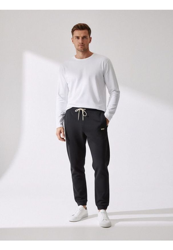 Sinsay - Spodnie dresowe - czarny. Kolor: czarny. Materiał: dresówka