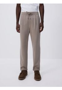 Reserved - Spodnie jogger z wiązaniem w pasie - beżowy. Kolor: beżowy. Materiał: bawełna, dzianina #1