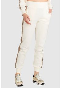 Guess - GUESS Kremowe spodnie damskie z lampasami w logo. Kolor: kremowy. Materiał: bawełna. Wzór: aplikacja