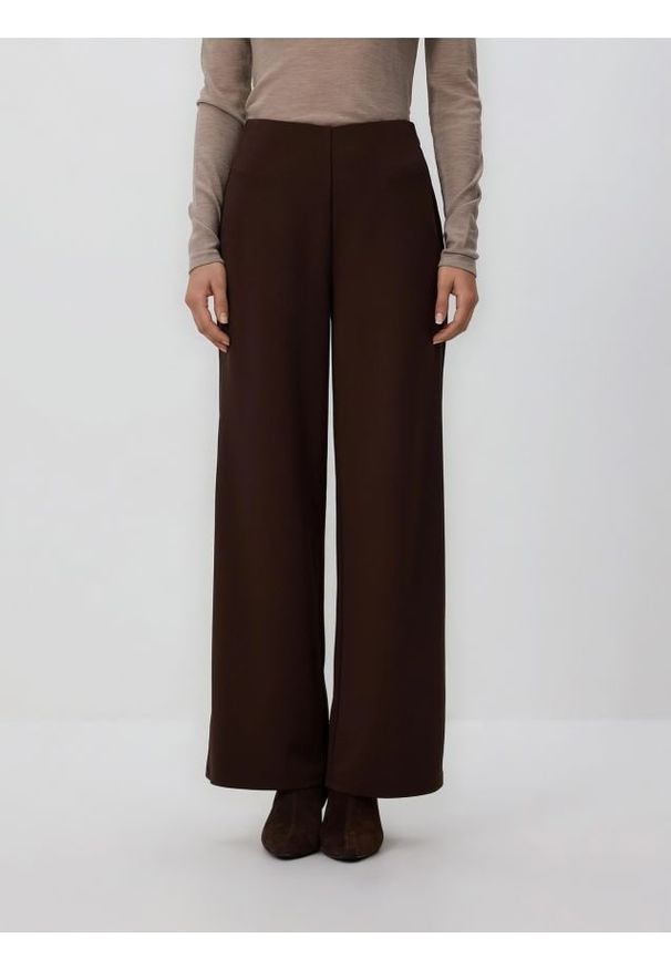 Reserved - Spodnie z szerokimi nogawkami - ciemnobrązowy. Kolor: brązowy. Materiał: tkanina. Wzór: gładki
