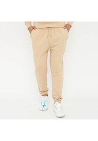 LEGEA - Spodnie sportowe unisex F BALLON beżowe. Kolor: beżowy. Materiał: guma. Sport: fitness #1