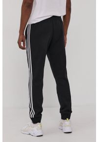 Adidas - adidas Spodnie męskie kolor czarny z aplikacją. Kolor: czarny. Wzór: aplikacja