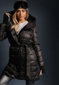 Renee - Czarna Kurtka Pikowana o Długim Kroju z Kapturem Ozdobiona Wiązaniem w Talii Anselith. Typ kołnierza: kaptur. Kolor: czarny. Materiał: jeans. Długość: długie. Wzór: aplikacja. Styl: elegancki