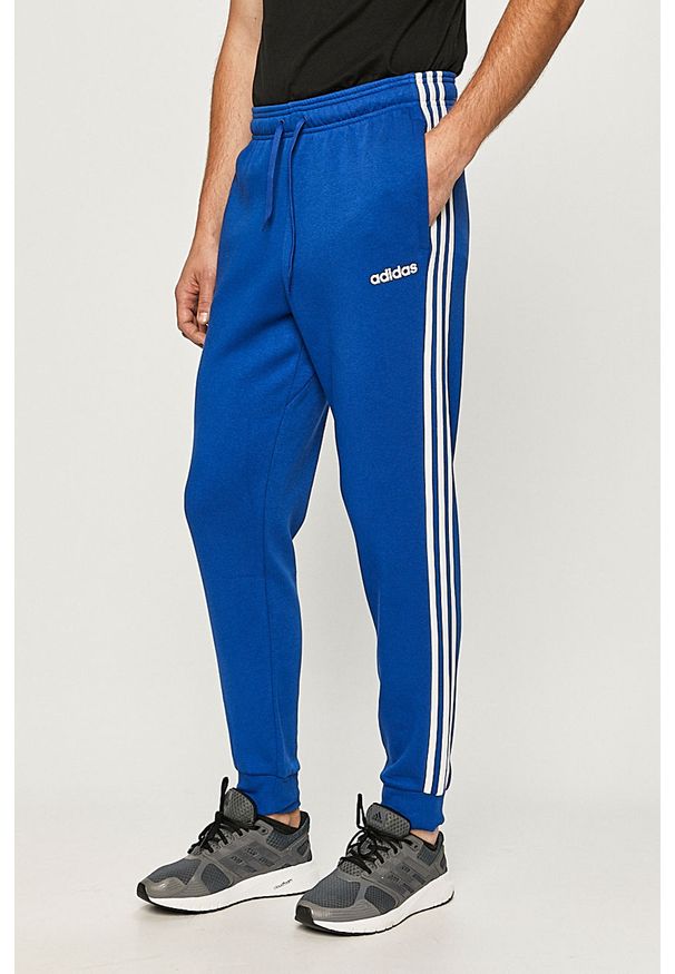 Adidas - adidas - Spodnie. Kolor: niebieski. Materiał: bawełna, poliester, dzianina. Wzór: nadruk, aplikacja
