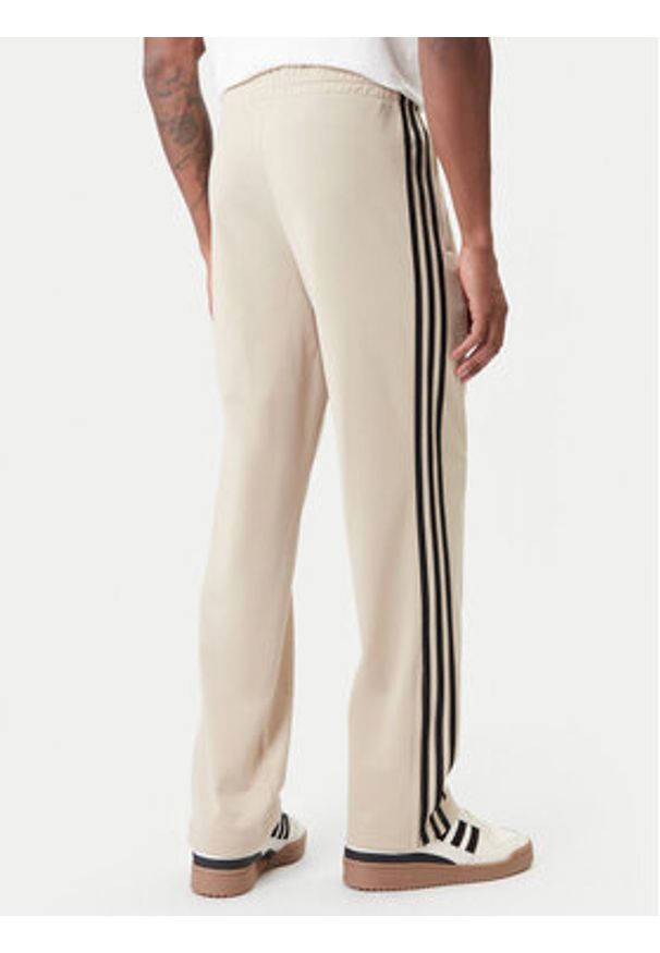 Adidas - adidas Spodnie dresowe Firebird KE6679 Beżowy Loose Fit. Kolor: beżowy. Materiał: syntetyk