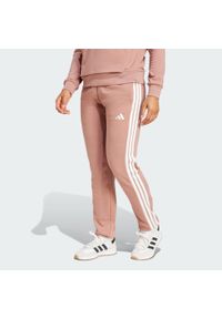 Adidas - Spodnie Essentials 3-Stripes French Terry Cuffed. Kolor: różowy, biały, wielokolorowy. Materiał: materiał. Sport: fitness