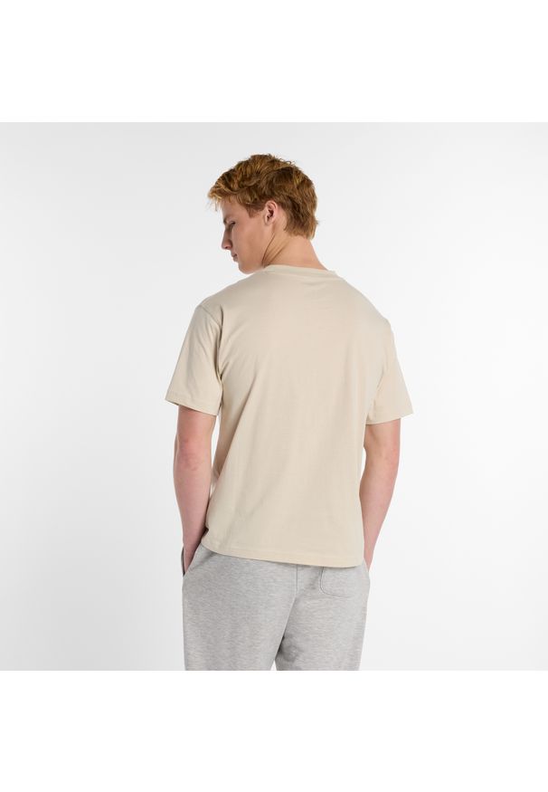 Koszulka męska New Balance MT51507TWF – beżowa. Kolor: beżowy. Materiał: bawełna, dresówka. Wzór: aplikacja, napisy