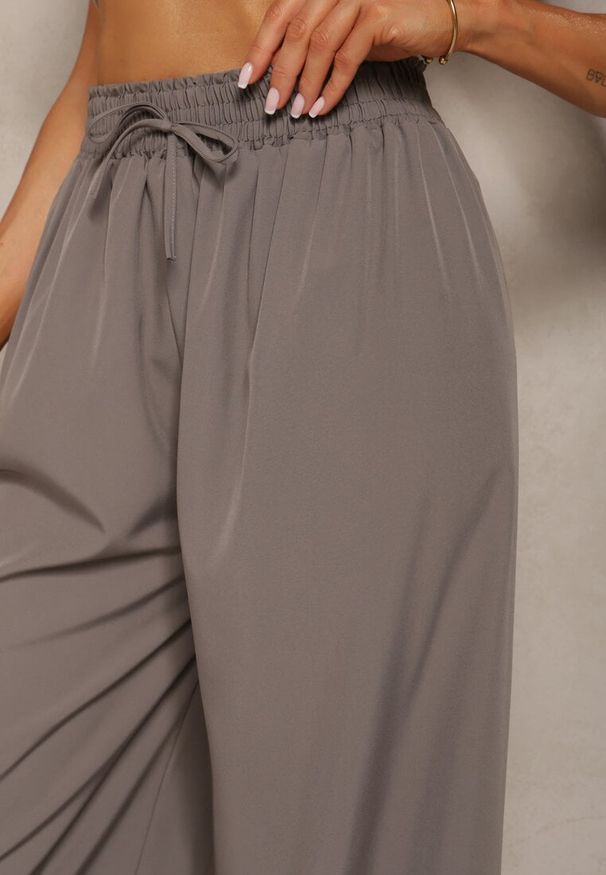 Renee - Szare Spodnie High Waist z Szerokimi Nogawkami z Wiskozą Wykończone Gumką w Talii Crisantas. Okazja: na spotkanie biznesowe, na co dzień. Stan: podwyższony. Kolor: szary. Materiał: wiskoza. Styl: biznesowy, elegancki, casual
