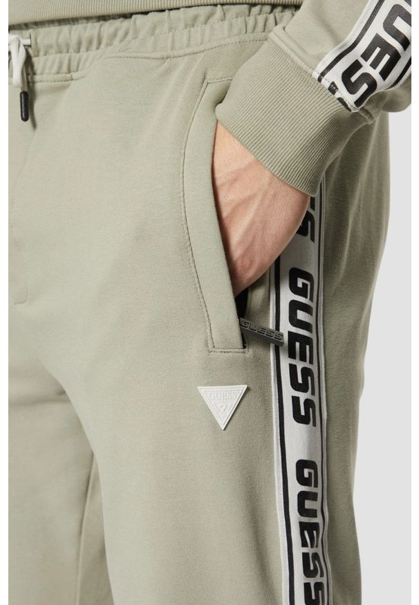 Guess - GUESS Zielone męskie spodnie dresowe z lampasami New Arlo, Rozmiar XL. Kolor: zielony. Materiał: dresówka