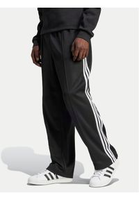 Adidas - adidas Spodnie dresowe adicolor Firebird IZ4801 Czarny Baggy Fit. Kolor: czarny. Materiał: bawełna #1