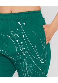 JOANNA MUZYK - Zielone spodnie dresowe Love Me. Stan: podwyższony. Kolor: zielony. Materiał: dresówka. Wzór: napisy, aplikacja