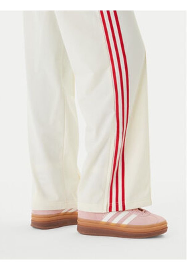 Adidas - adidas Spodnie dresowe Firebird KQ8056 Beżowy Loose Fit. Kolor: beżowy. Materiał: syntetyk